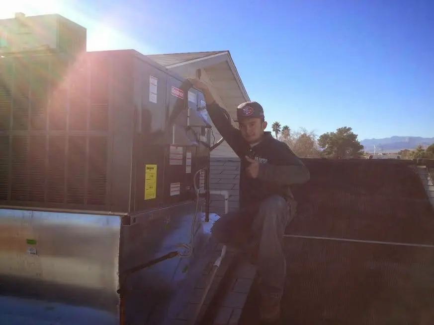 HVAC technician performing Air Duct Repair on a rooftop unit in Sanford